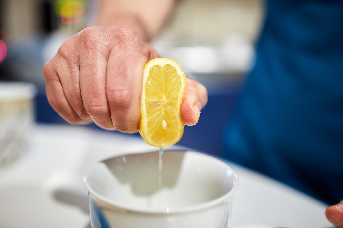 Выжимает лимон в миску
